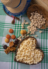 Festa junina in Brazil, typical festa junina table in brazil with popcorn and typical sweets and props, black background, top view.
