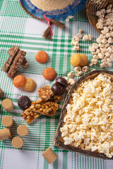 Festa junina in Brazil, typical festa junina table in brazil with popcorn and typical sweets and props, black background, top view.