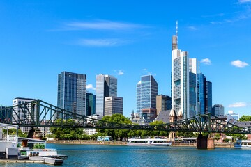 Naklejka premium Beautiful view on Frankfurt am Main skyline cityscape with blue sky, clouds, Main river, bridge Eiserner Steg in spring. Hessen, Hesse, Germany.
