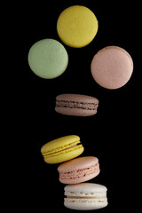 Macaroon. Colorful cake macaron with pastel tones fall at the stack macaroon on black background. Top view of almond cookies.