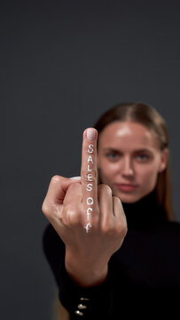 Young woman showing middle finger with sales off inscription