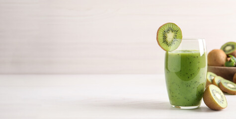 Delicious kiwi smoothie and fresh fruits on white wooden table. Space for text