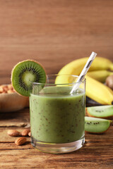 Delicious kiwi smoothie and ingredients on wooden table