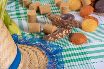 Festa Junina in Brasil, straw hat highlighted and several sweets in the background, selective focus..