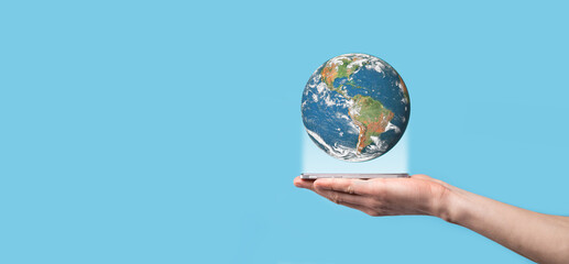 3D Earth planet globe in man, woman hand, hands on blue background. Environmental protection concept. Elements of this image furnished by NASA