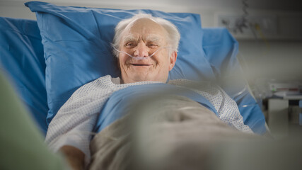 Hospital Ward: Portrait of Handsome Elderly Man Resting in Bed, Fully Recovering after Sickness and...