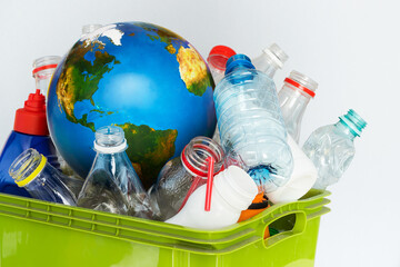Sorted plastic waste and a globe as a symbol of global plastic pollution. Recycling concept