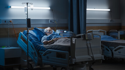 Hospital Ward: Portrait of Elderly Man Wearing Oxygen Mask Resting in Bed, Struggling to Recover after Covid-19, Sickness, Disease, Surgery. Old Man Fighting for His Life. Dark Blue Sad Shot