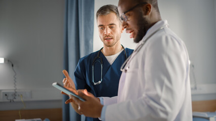 Hospital Ward: Black Doctor Talks With Professional Caucasian Head Nurse or Surgeon, They Use...