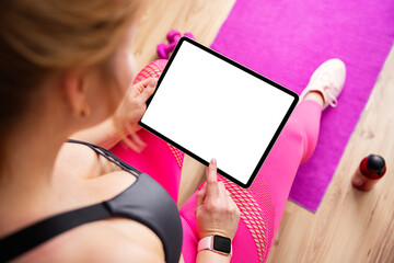 Woman holding tablet with blank screen during fitness training