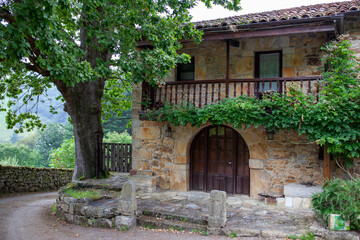 Fototapeta na wymiar Recodo en el camino con casa de piedra cerca de San Miguel de Luena (Cantabria, España)