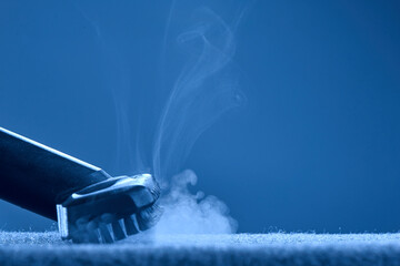 Home cleaning. Steam carpet cleaning on blue background. Photo with copy space.