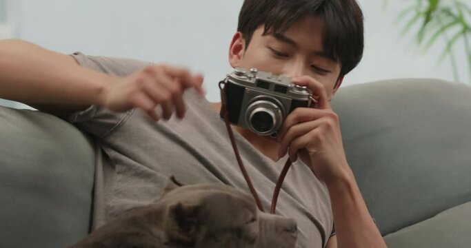 Young Chinese man taking pictures of his pet dog at home,4K