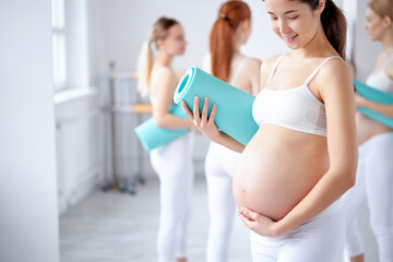 cropped photo of young female with big pregnant belly posing