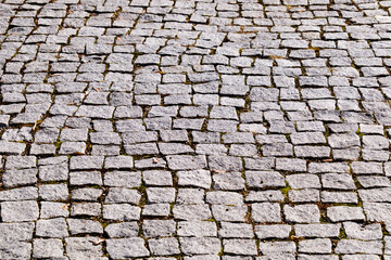 Irregular gray-pink pavement made of broken boulders.