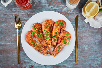 Grilled large queen shrimps with lemon and spices on the plate