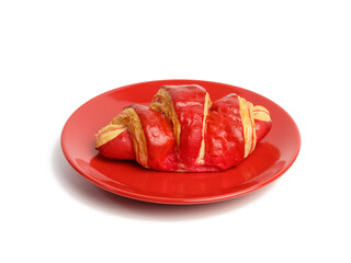 baked croissants with cherry glaze on a red ceramic plate,
