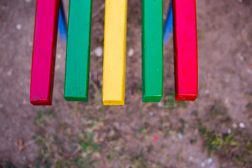 Chair painted with different colors, located in the park.