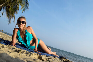 Beautiful Girl in a swimsuit on the beach. Tropical Landscape