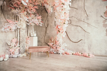 Pink wedding photo zone in studio made of white flowers. Place for making pictures. Candles and...