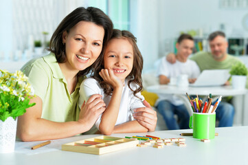 Cute little girl with her mother studying