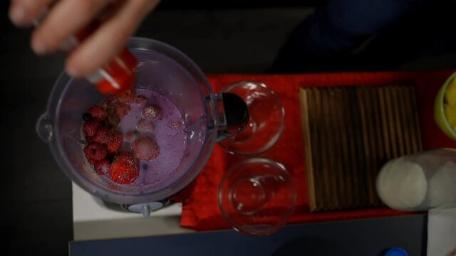 making strawberry red fruit smoothie in a blender 