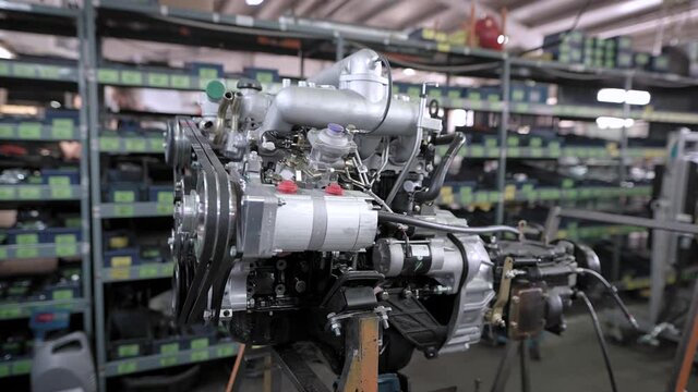 A new car engine in the production hall on a special stand.