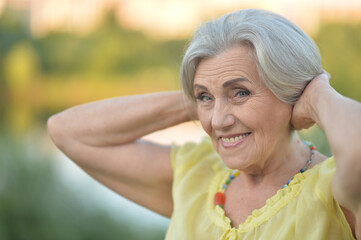 Smiling senior woman in park in summer