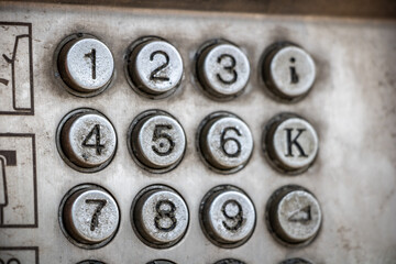 numbers iron gris buttons on an old abandoned telephone cabin