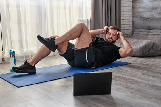athlete man pumping press on floor during online workout at home