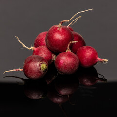 Radishes on reflective black background