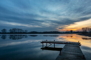 Wooden fishing pier and beautiful evening clouds over the lake, Stankow, Poland