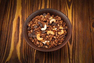 Chocolate granola cereal with nuts in a bowl.