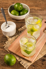 Brazilian Caipirinha. Cachaça drink with lemon, on rustic wooden background.