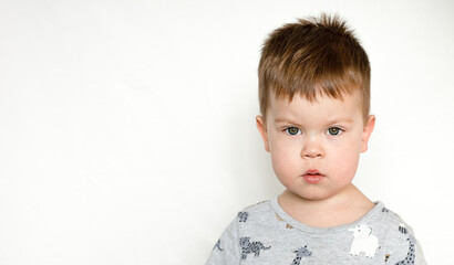 portrait of little sad calm baby boy face with emotional looking isolated background with copy space