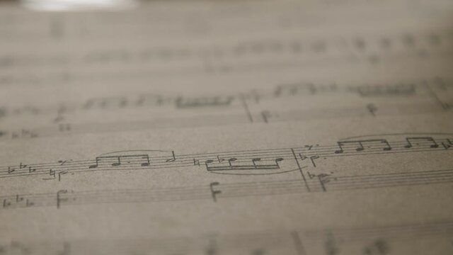 Turning over musical notes close up in daylight