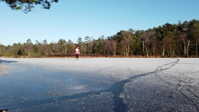 Ice Skaters Skating On A Frozen Lake Covered In Ice And Snow In Winter