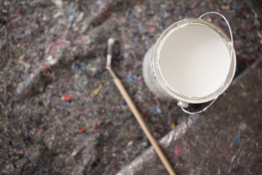 Paint buckets and painting accessories are laid out on painted fleece ready for painting the walls brush and masking tape drip protection paint blobs specialist knowledge preparation renovation tool