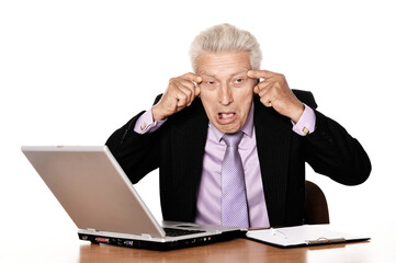 Old businessman  working with laptop and making face