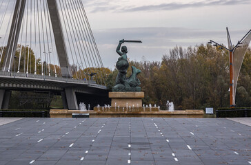 Fototapeta premium Monument of Mermaid on a boulevards over Vistula River in Warsaw, view with Swietokrzyski Bridge, Poland