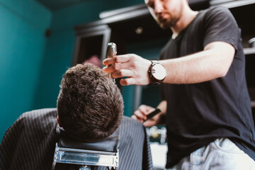 Close-up professional barber doing hair cut