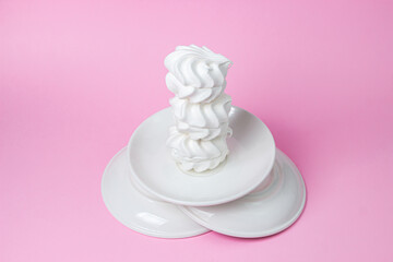White marshmallow on a pink background. White marshmallow on a white plate. Light dessert