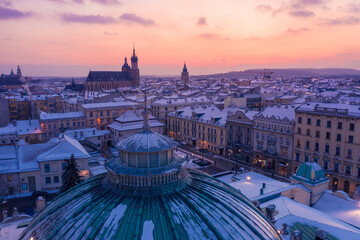 Snowy winter in Krakow Poland aerial view. City center old town, Roof of Juliusz Slowacki Theatre, and Rynek Glowny with St. Mary's Basilica and Town Hall Tower on background. - obrazy, fototapety, plakaty