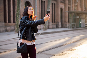 young woman sending a kiss by making a video call