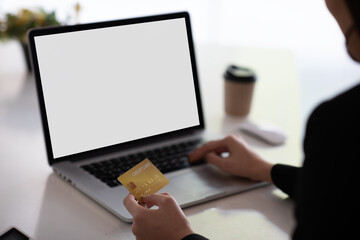 Close up woman hand using credit card and laptop with blank screen for buying online shoppin