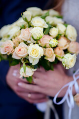 The bride holds a wedding bouquet in her hands