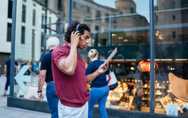 Millennial hipster guy in bluetooth headphones for noise cancellation listening music playlist...
