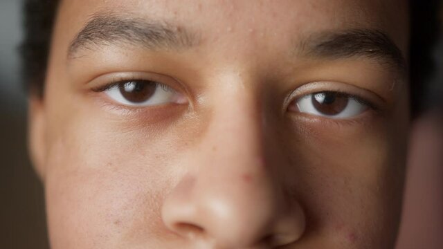 Close up black African American boy portrait, high school teenager looking at camera, international education concept. 