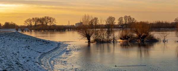 Ice skating on frozen floodplains during sunset in the Netherlands