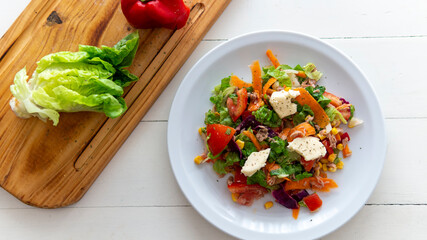 flat lay of  a fresh tasty salad on top of a white table